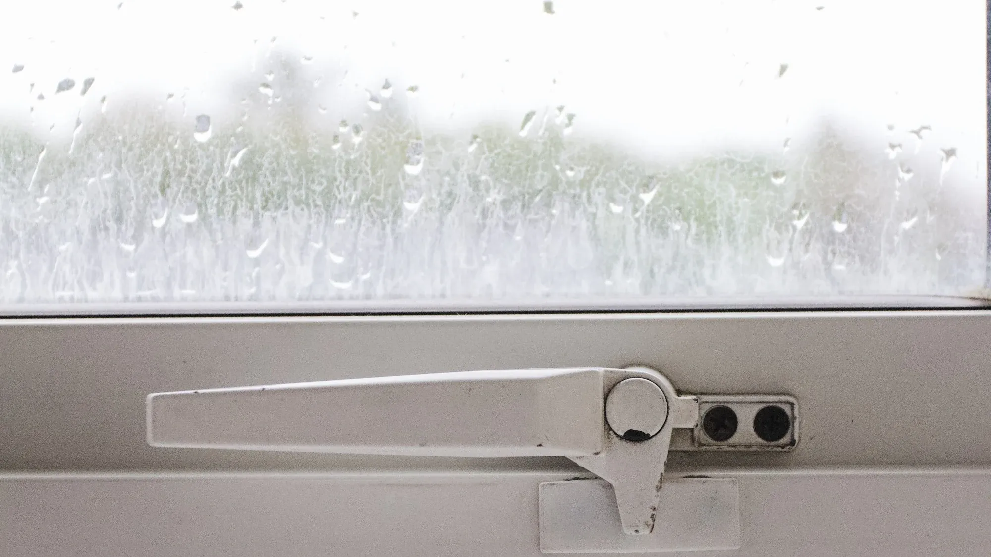 Kondenswasser am Fenster über dem Fenstergriff