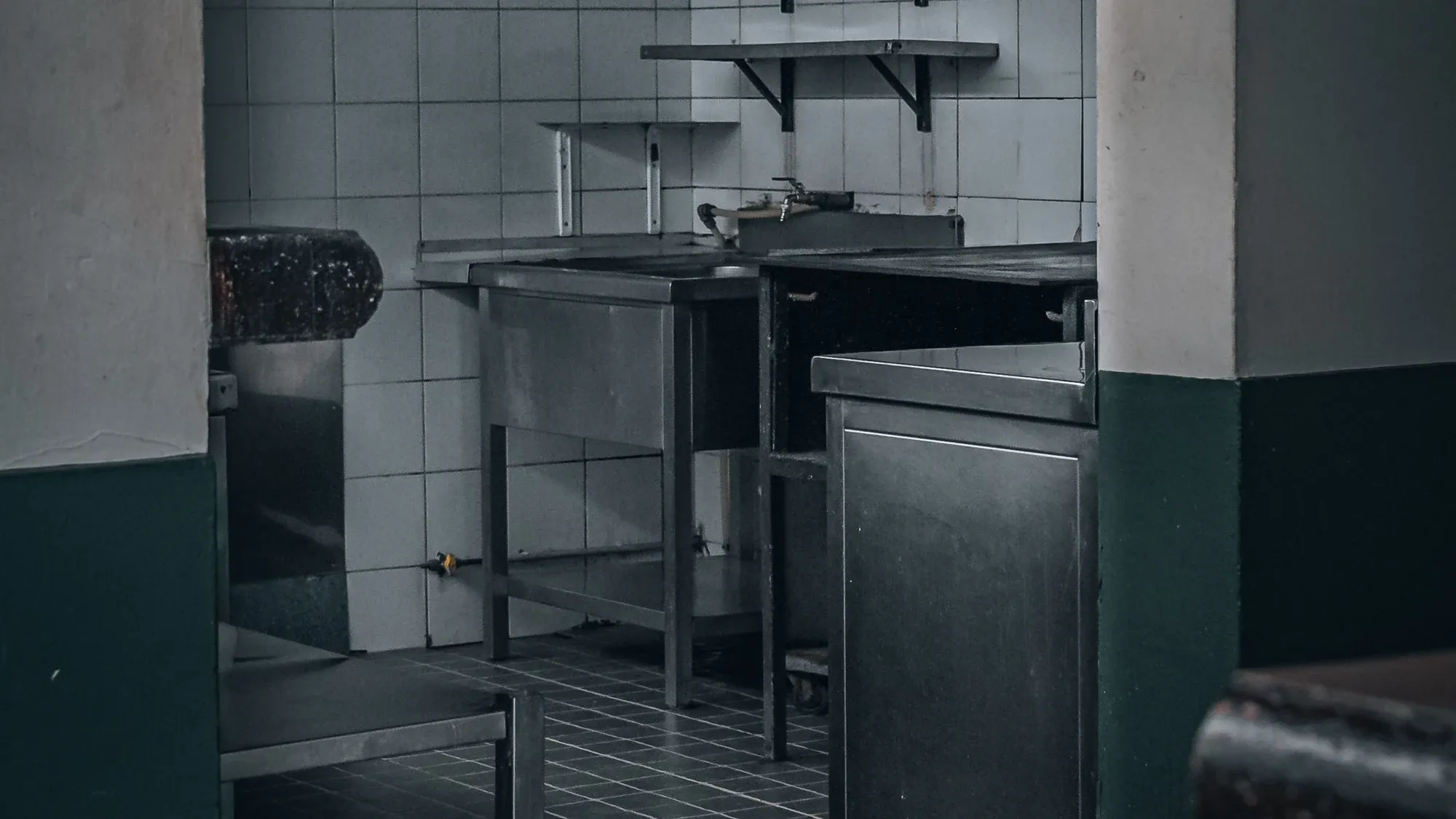 Dunkle Gastroküche mit Edelstahlmöbeln
