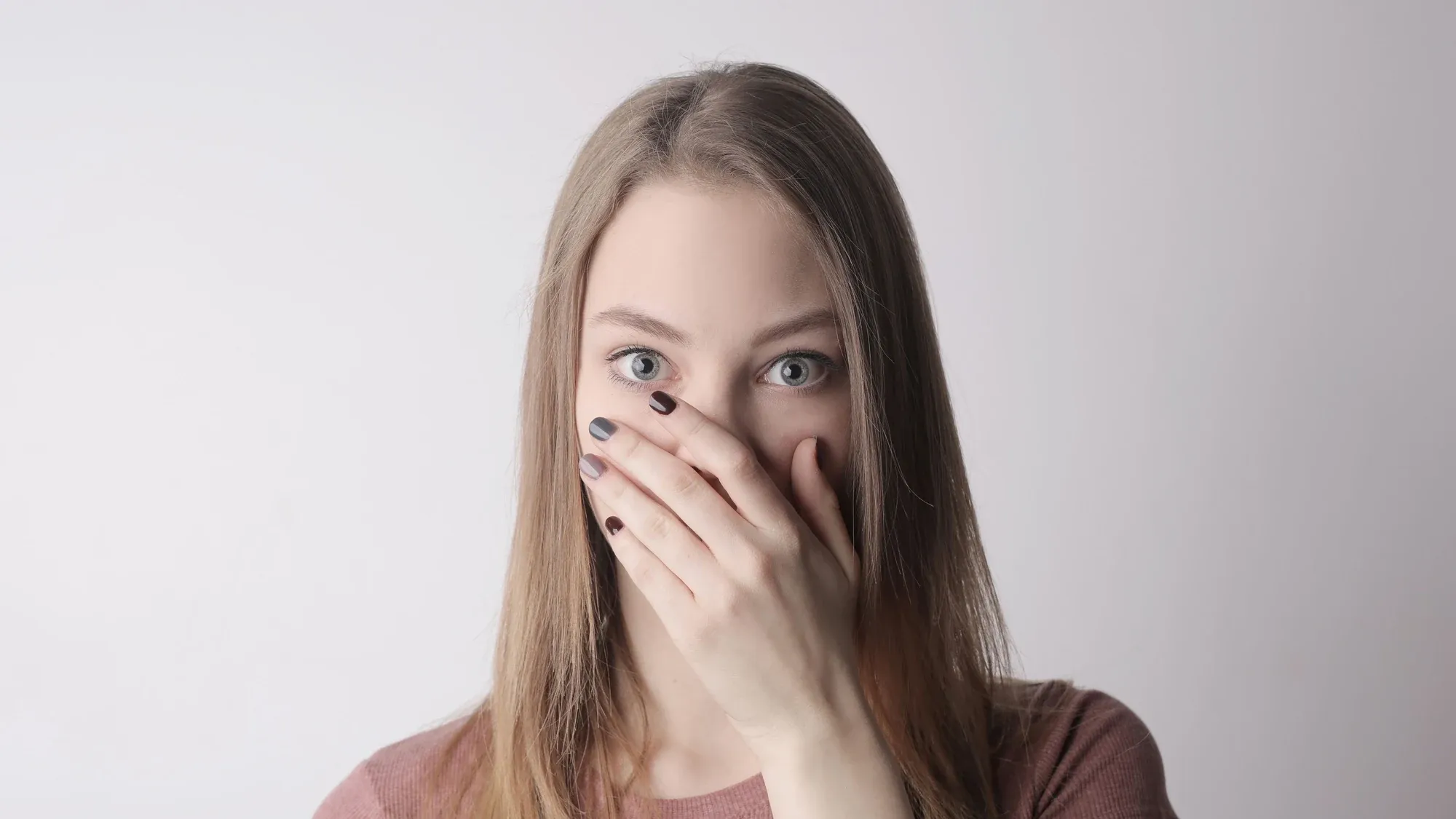 Frau hält sich Hand vor Nase und Mund