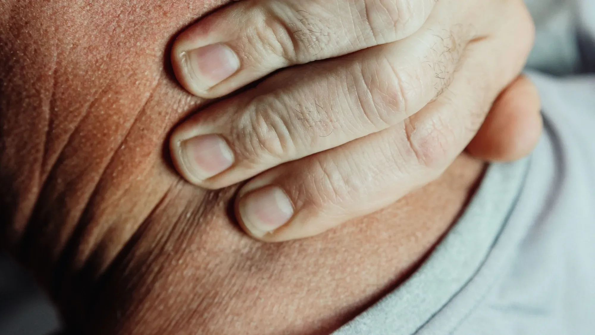 Hand kratzt sich am Nacken