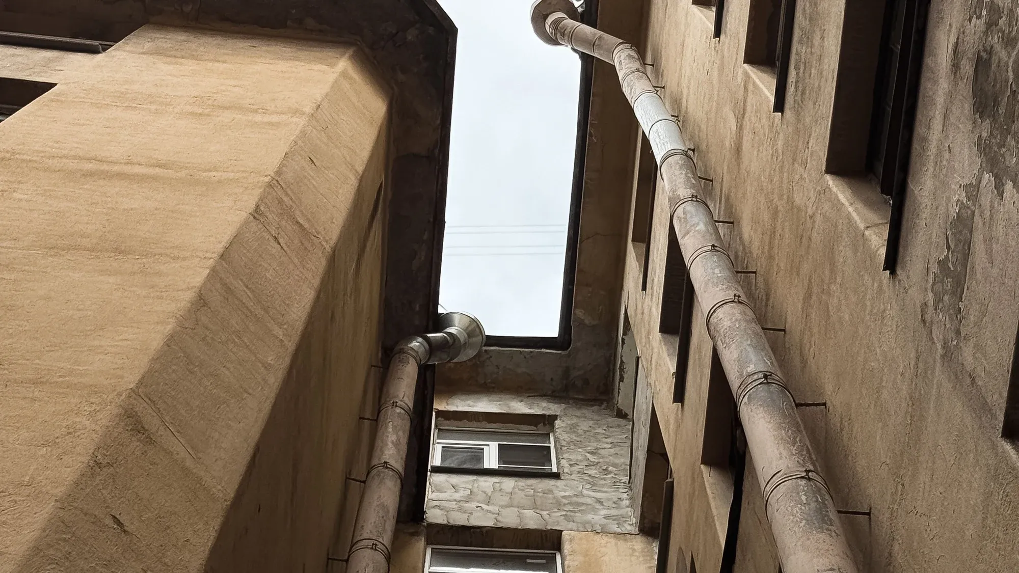 Innenhoffassade mit Dachrinnen und Fallrohren von unten